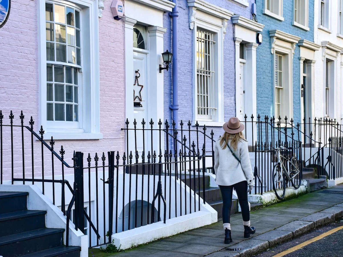 exterior-painting-woman-walking-past-surrey-decorators Masonry painting in Surrey by Surrey Decorators, exterior view of painted rendered property