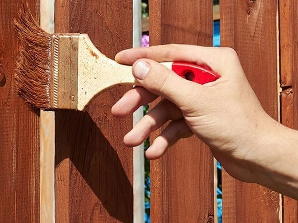 fence-painting-hand-wooden-garden-surrey-decorators Hand applying fence paint to wooden garden fence panels, Surrey Decorators