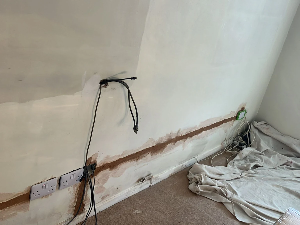 A wall with patched plaster and fresh filling, ready to be prepared before painting