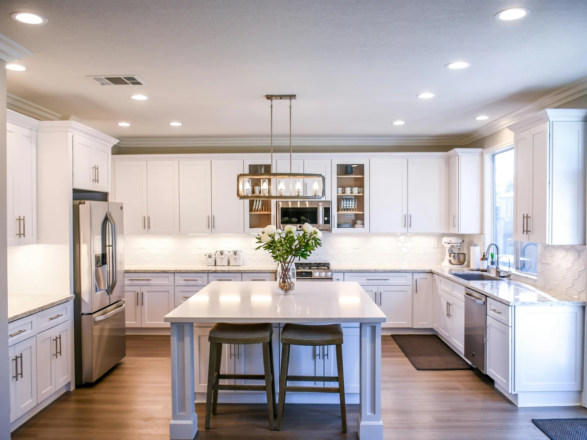 kitchen-painting-bright-white-kitchen-surrey-decorators A bright white kitchen with an island, pendant lights and clean painted cabinets